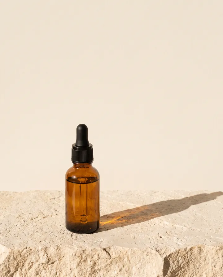 Serum bottle on limestone in hard sunlight.